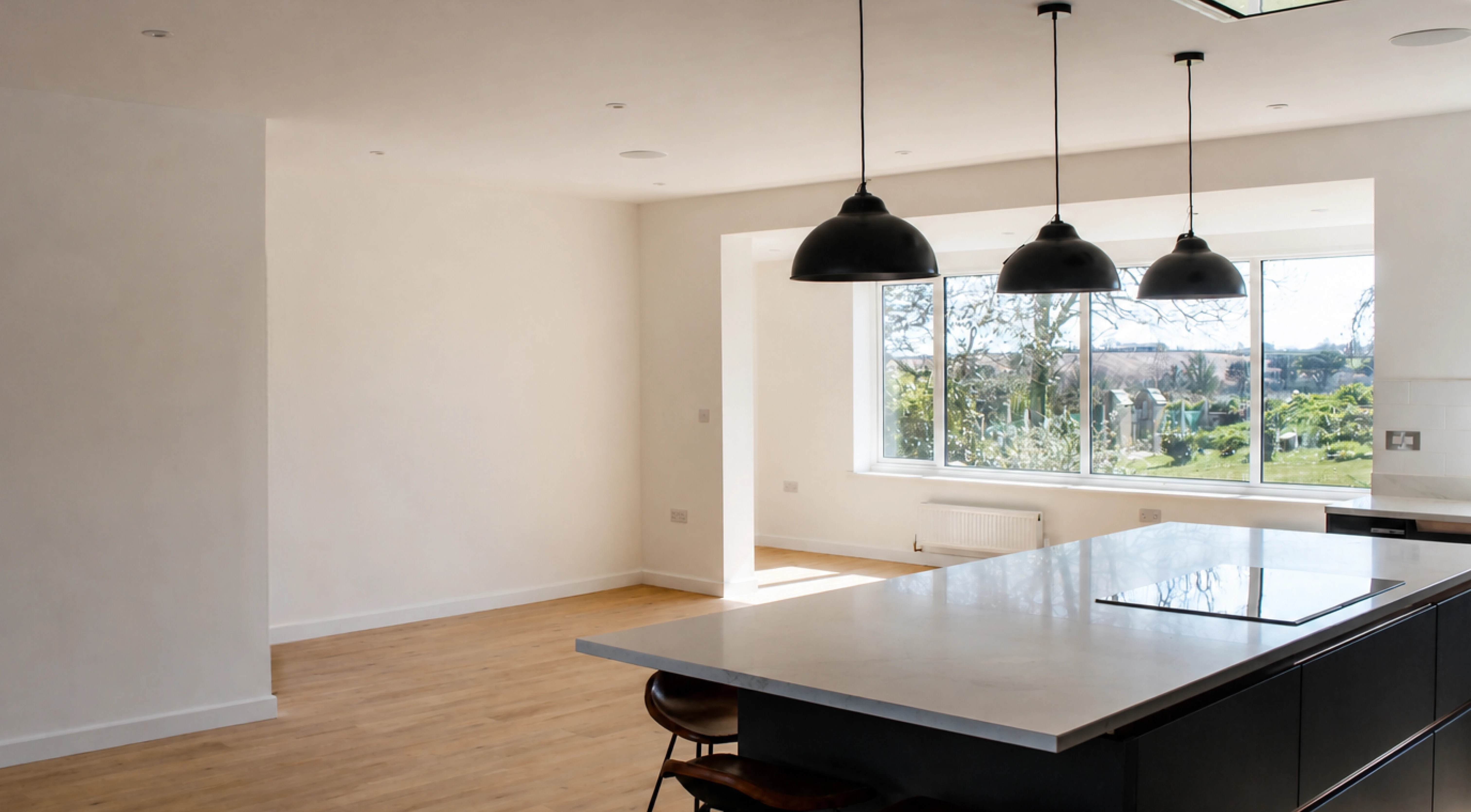 A finished kitchen and living space with a garden outlook